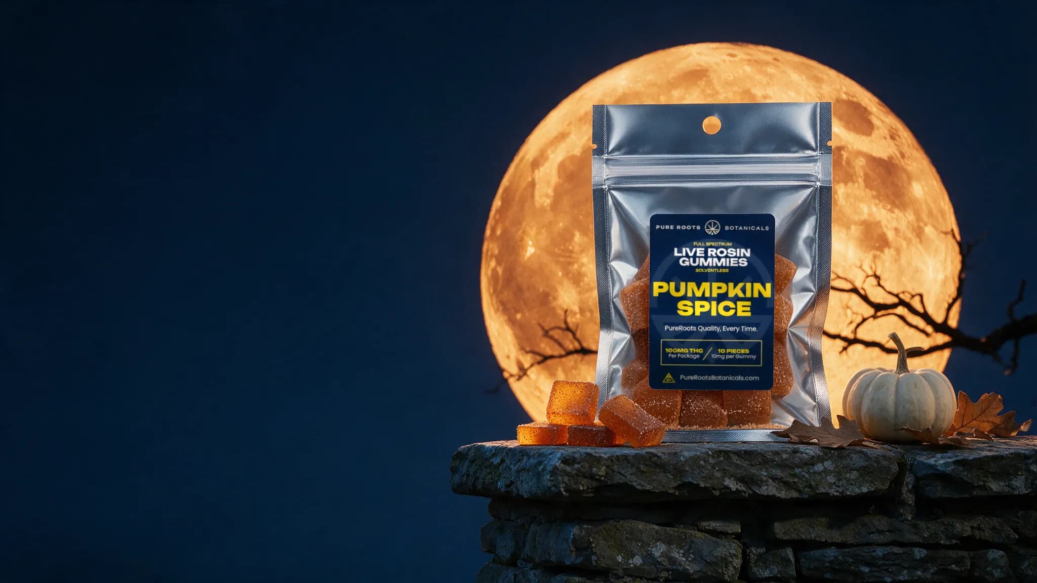 A silver Pure Roots Pumpkin Spice live rosin gummies pouch on a stone wall at night in front of a huge orange harvest moon, with sugar-coated gummies and a small white pumpkin