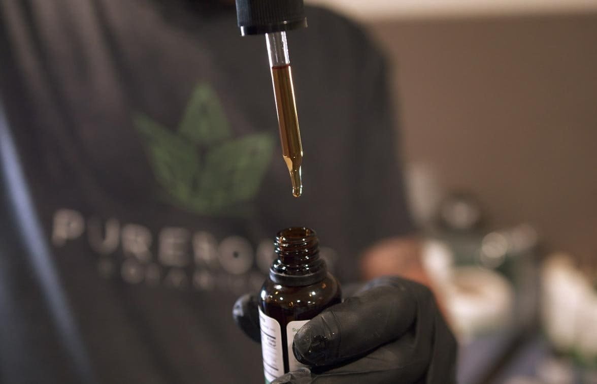 A man holding CBD Tincture Dropper With Oil Inside